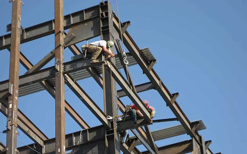 Fitters laying new roof sheets on a steel frame