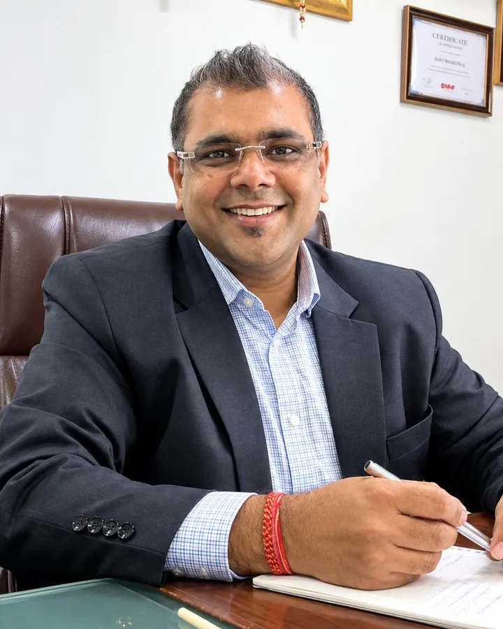 Manu Gupta at his desk, pen in hand